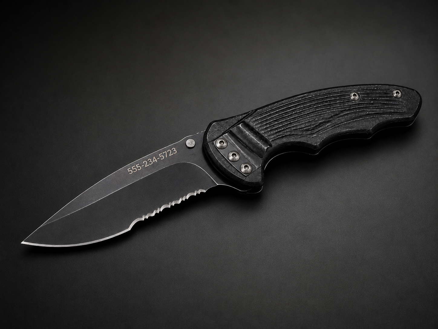 Black folding knife with laser-engraved phone number on the blade