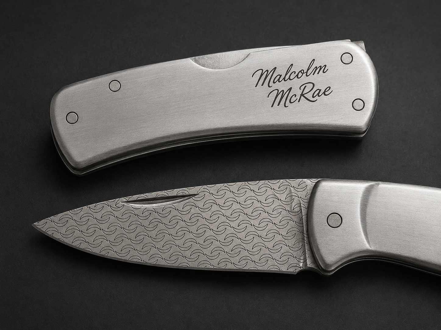 Custom engraved folding knife with patterned blade and personalized handle engraving
