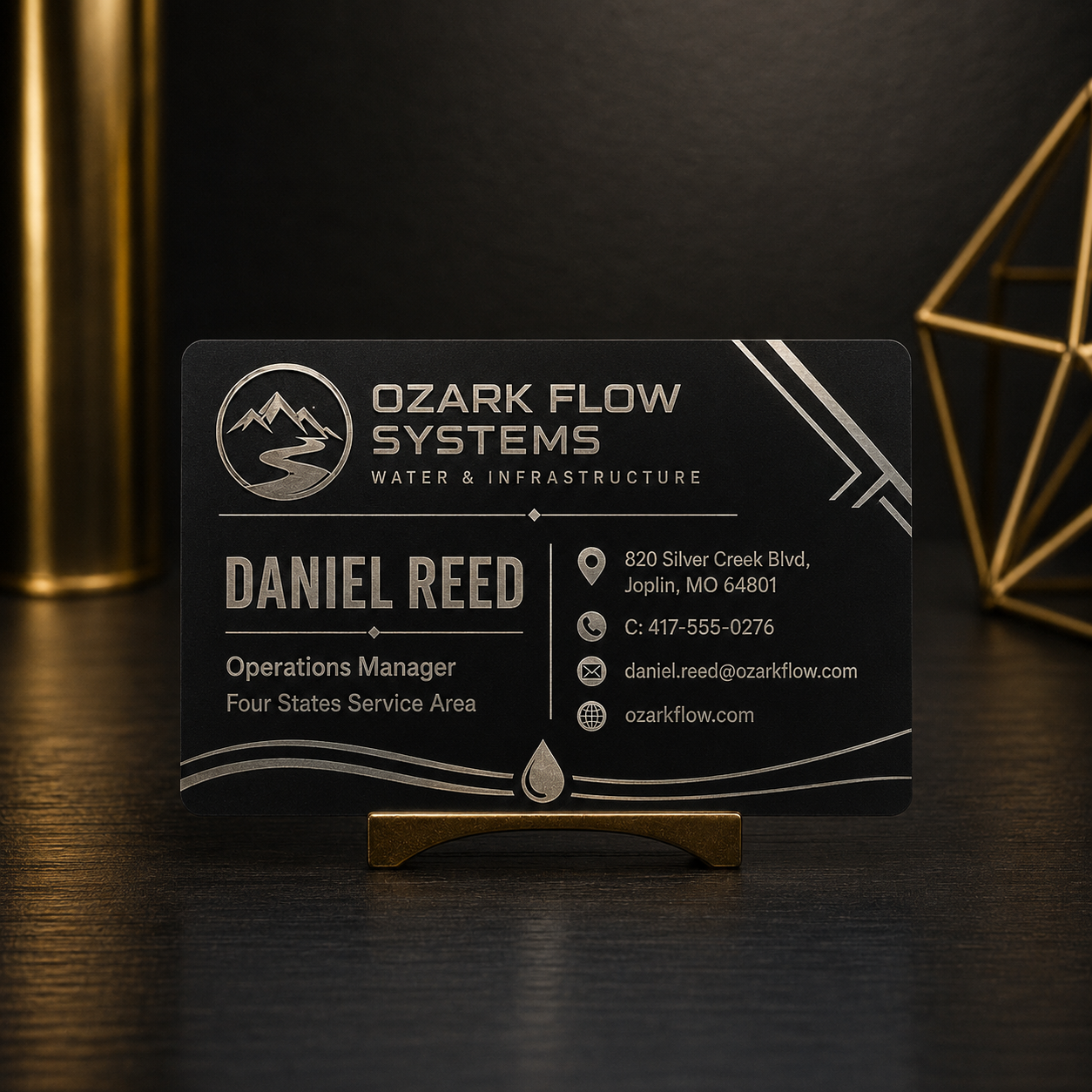 Engraved metal business card on a gold stand